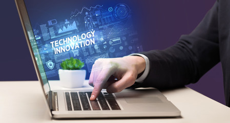 Fototapeta na wymiar Businessman working on laptop with TECHNOLOGY INNOVATION inscription, cyber technology concept