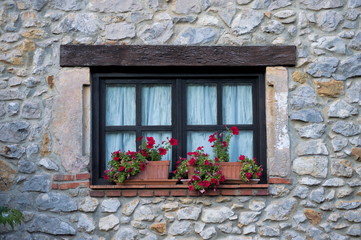 Fototapeta na wymiar A flowery window in a typical house of Cantabria, Spain