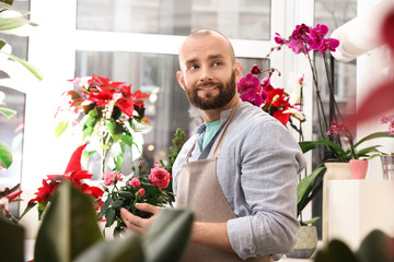 Professional male florist in apron at workplace