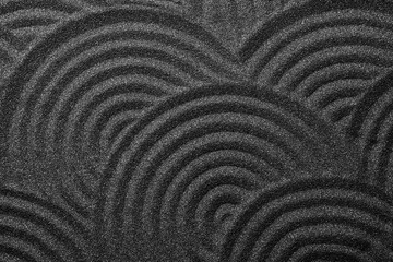 Black sand with beautiful pattern, top view. Zen concept