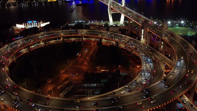Aerial drone 4k video scene of traffic on Nanpu Spiral road at night, Nanpu bridge, Huangpu River,  Shanghai, China