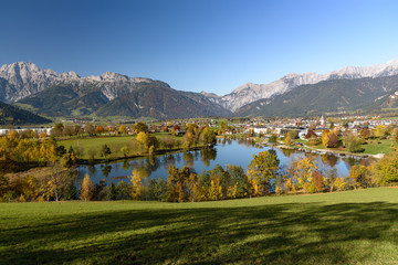 Panoramic view of Lake Ritzensee and Saalfelden on a sunny autumn day in with the mountains Steinernes Meer in the background. Saalfelden, Pinzgau, Salzburg Land, Austria. - obrazy, fototapety, plakaty