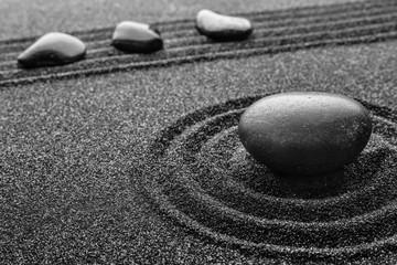 Fototapeta na wymiar Black sand with stones and beautiful pattern. Zen concept
