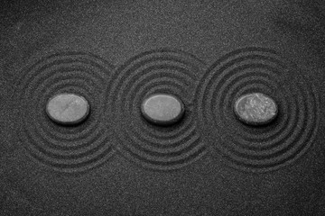 Black sand with stones and beautiful pattern, flat lay. Zen concept