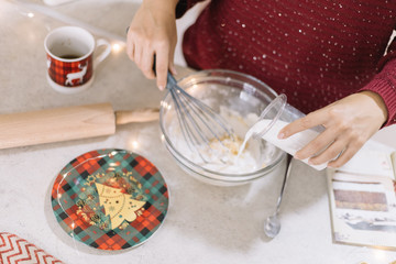 Woman pouring milk into bowl with cookies dough