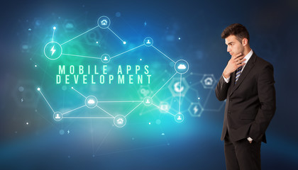 Businessman in front of cloud service icons with MOBILE APPS DEVELOPMENT inscription, modern technology concept