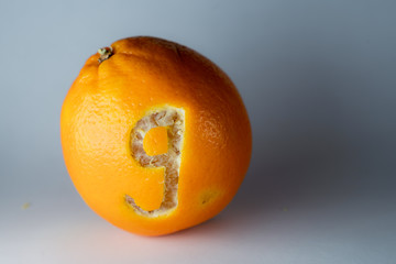 Nummer 9 einer Schriftart in die Schale einer Orange geritzt