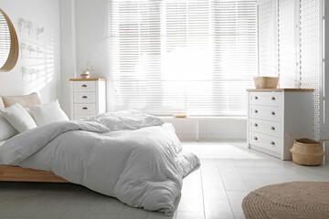Stylish bedroom interior with white chest of drawers