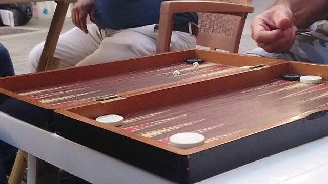 A man throwing dice to backgammon board. Super Slow Motion.