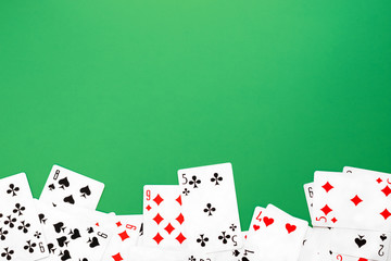 Deck of playing cards on green background table copy space