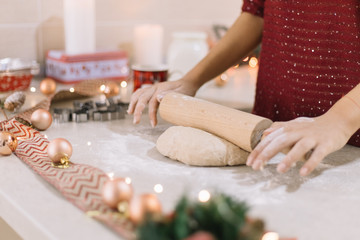 Obraz na płótnie Canvas Woman's hands rolling gingerbread dough on countertop