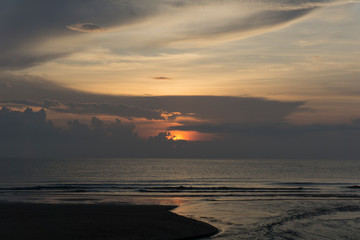 Obraz premium Beautiful dawn, morning sun rises by the sea. Scenic beach, coastline, rocks, cloudscape and skyline photography. Sunrise during the early hours of a summer morning by the beach. Sunset by the beach.