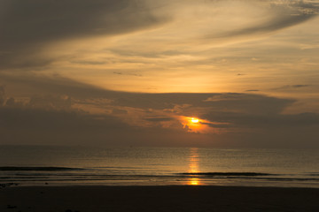 Beautiful dawn, morning sun rises by the sea. Scenic beach, coastline, rocks, cloudscape and skyline photography. Sunrise during the early hours of a summer morning by the beach. Sunset by the beach.