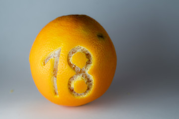 Zahl 18 für einen Adventskalender in die Schale frischer Orangen geschnitzt