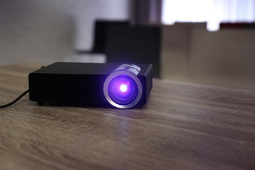 Modern video projector on wooden table in conference room