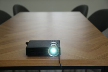 Modern video projector on wooden table in conference room