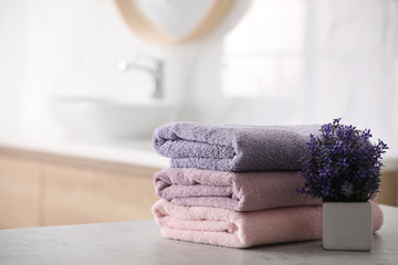 Stack of fresh towels on table in bathroom. Space for text