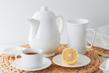 White ceramic tableware, fibre braided round placemat and cutlery set on white background. Scandinavian style