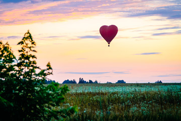 Fototapeta premium Heart shaped balloon soars in the sky