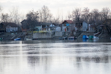 houses at the riverbank in autumn, tisa river near zrenjanin, serbia