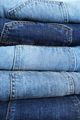 Stack of different jeans as background, closeup