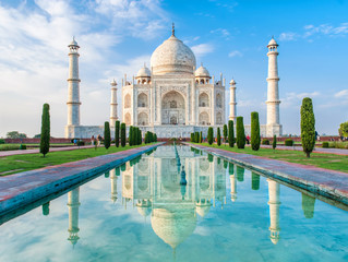 Amazing view on the Taj Mahal in sunset light with reflection in water. The Taj Mahal is an...