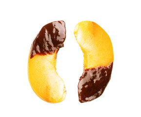 Slices of peach in chocolate on a white background