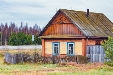 Fototapeta premium Abandoned ancient wooden house by the road.