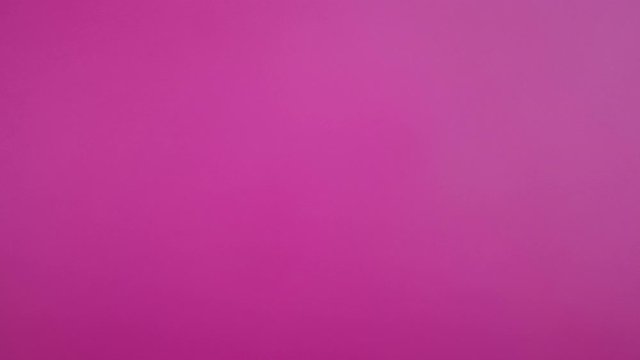 Top view of pink doughnut. Eating delicious donut on pink background. Timelapse. Bakery and food concept in 4K, UHD