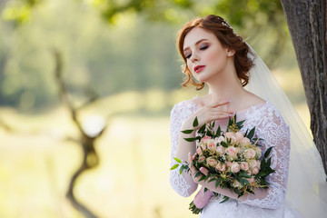 Beautiful redhead Bride. Portrait of a young woman under tree. Pretty young caucasian redhead girl...