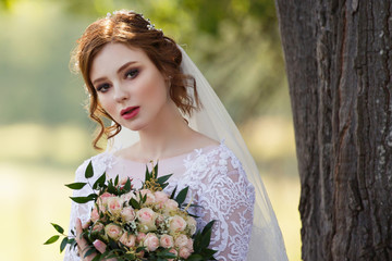 Beautiful redhead Bride. Portrait of a young woman under tree. Pretty young caucasian redhead girl...