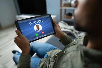 Man Holding Digital Tablet With Doctor's Call On Display