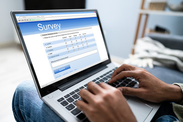 Man Filling Online Survey Form On Laptop