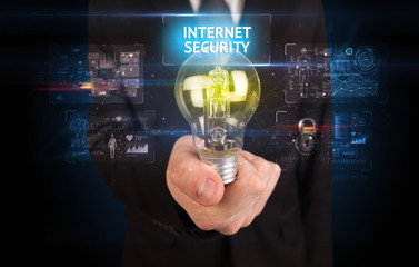 Fototapeta na wymiar Businessman holding lightbulb with INTERNET SECURITY inscription, online security idea concept