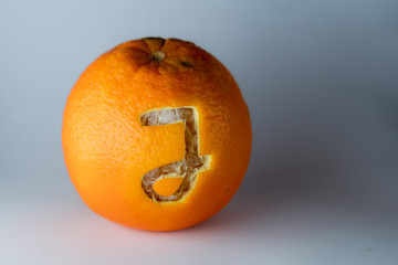 Buchstabe j einer Schriftart in die Schale frischer Orangen geschnitzt