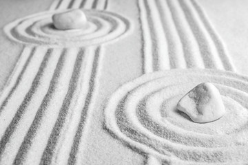 Fototapeta na wymiar White stones on sand with pattern. Zen, meditation, harmony