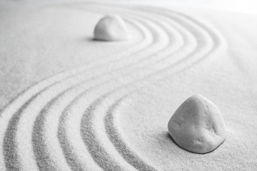 Fototapeta na wymiar White stones on sand with pattern. Zen, meditation, harmony