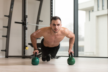 Bodybuilder Doing Push Ups On Floor With Kettle-bell