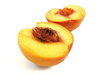 Halves of ripe fresh peach with seed closeup isolated on white background