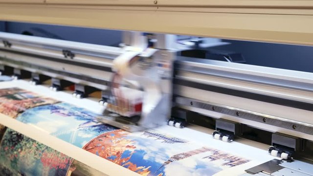 Industrial printing on woven material; modern digital inkjet printer puts a picture on a cloth canvas
