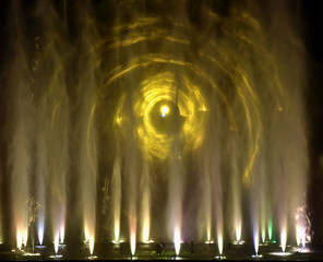 Colorful water fountains. Beautiful laser and fountains show. Large multi colored decorative dancing water jet led light fountain show at night. Dark background.