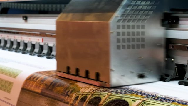 Industrial printing on woven material, modern digital inkjet printer puts a picture on a cloth canvas