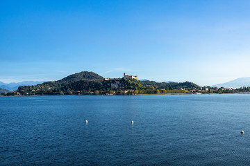 View of Rocca di Angera (Borromeo Castle) from Arona waterfront on the shores of Lake Maggiore, Piedmont, Italy.