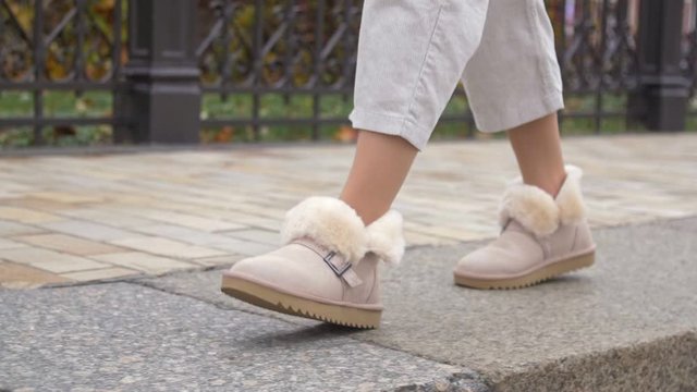 Woman walks in beige ugg winter boots close up