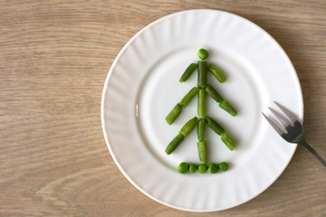 Edible Christmas tree made of french beans on white plate. Nice way to serve vegetables for holiday