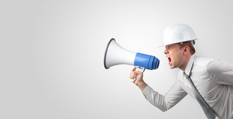 Fototapeta premium Young architect constructor yelling with megaphone and copyspace