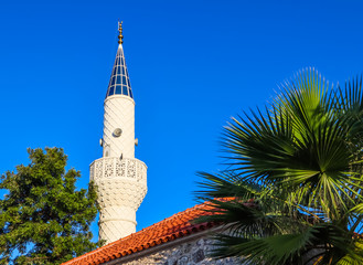 Fototapeta na wymiar Mosque Minaret on a background of blue sky in Bitez, Bodrum, Turkey