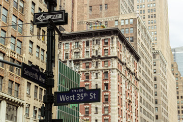 Signs in the urban center of New York city, surrounded by imposing buildings