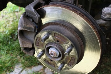 Detail of 13 years old rusty brake rotor and caliper assembly after wheel disc removal. 
