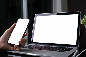 Mockup of man using mobile smart phone and laptop computer